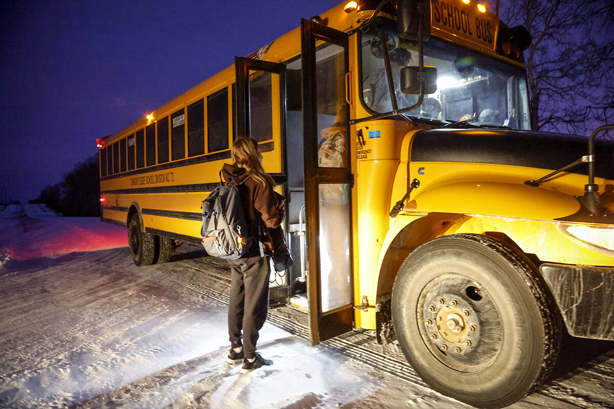 Alberta students board a school bus, as they return to school today for the first time since their holiday break was extended due to surging COVID-19 cases, near Cremona, Alta., Monday, Jan. 10, 2022. THE CANADIAN PRESS/Jeff McIntosh