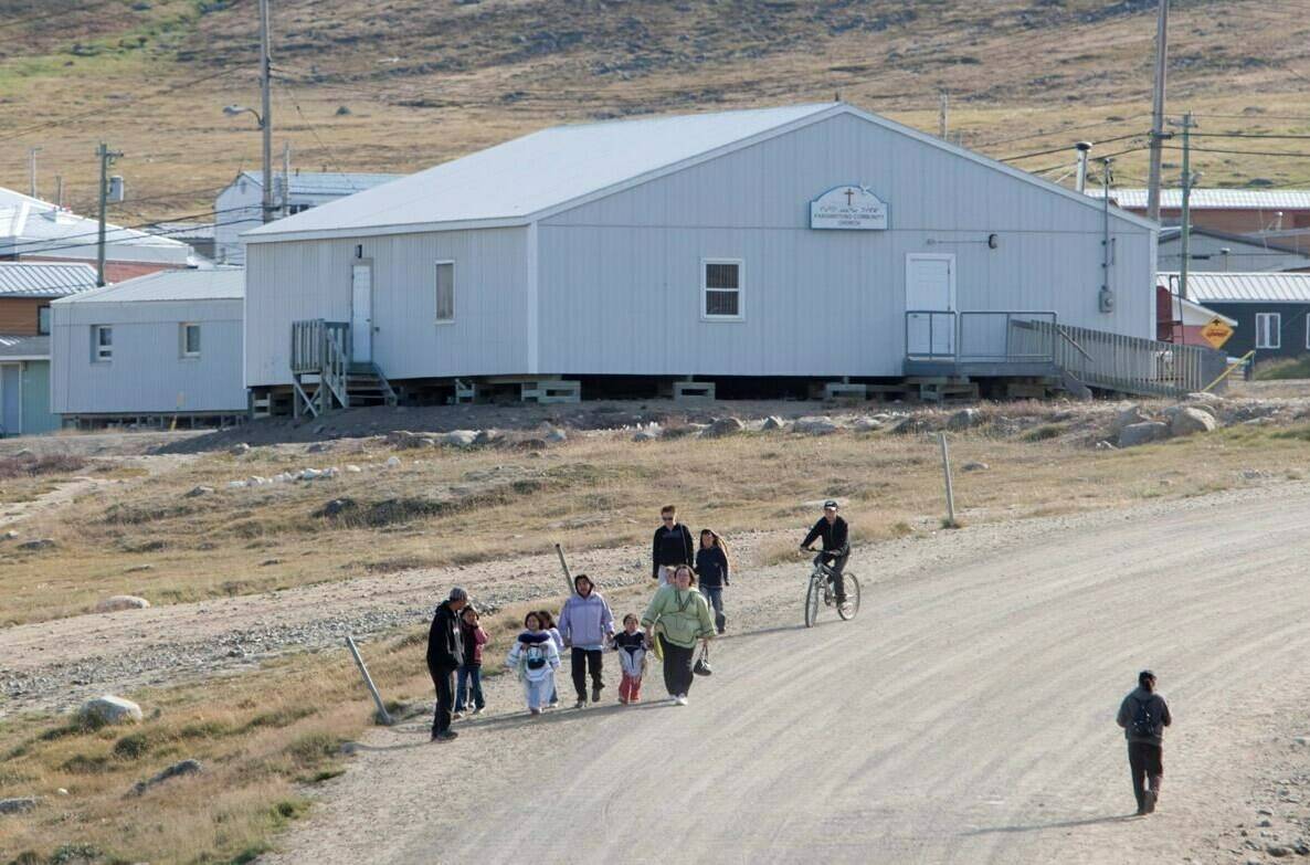 Residents walk through the streets of the hamlet of Pangnirtung, Nvt., on Thursday, Aug. 20, 2009. The community is fighting both tuberculosis and COVID-19 cases. Adrian Wyld/TCPI/The Canadian Press