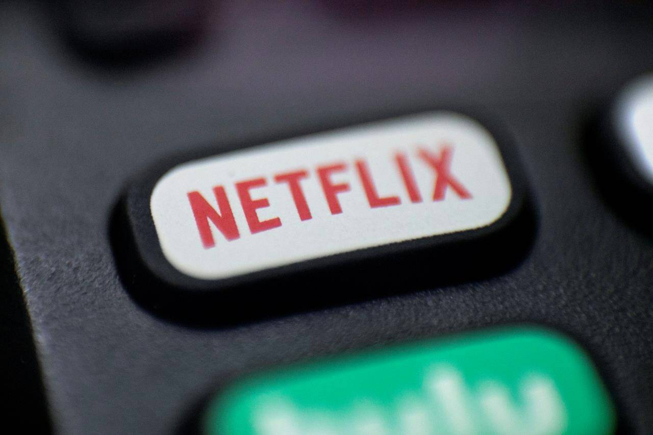 A logo for Netflix is seen on a remote control in Portland, Ore., Aug. 13, 2020. The global streaming platform announced last week it’s inching up the monthly cost of its most popular subscription packages once again by a dollar or two. THE CANADIAN PRESS/AP-Jenny Kane