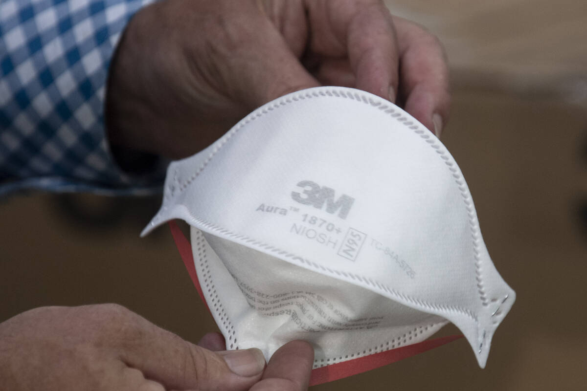 A man holds a 3M N95 respirator. THE CANADIAN PRESS/Adrian Wyld