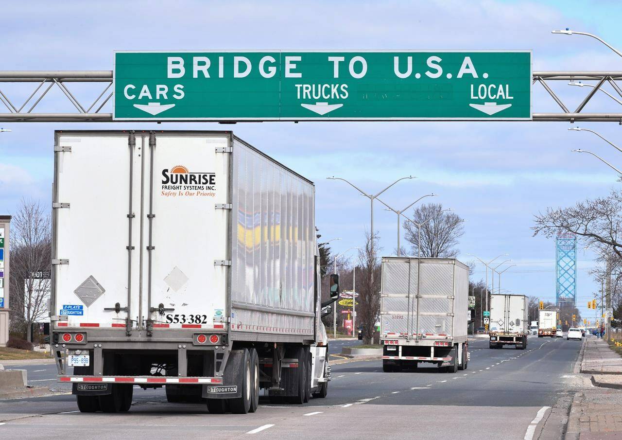 Transport trucks approach the Canada/USA border crossing in Windsor, Ont. on Saturday, March 21, 2020. Findings from an industry survey show that most in-house trucking fleets do not have a COVID-19 vaccine mandate, despite an impending inoculation requirement from the federal government. THE CANADIAN PRESS/Rob Gurdebeke