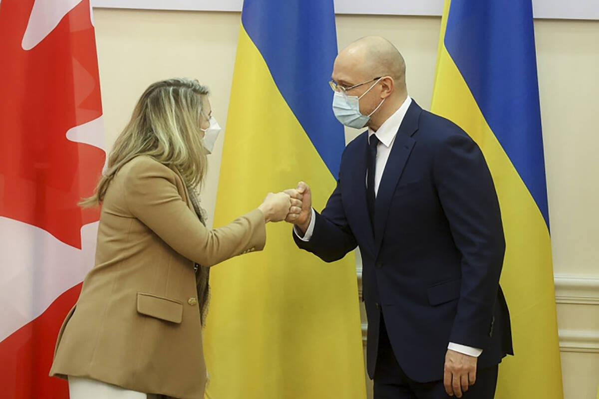 In this photo provided by Ukrainian Prime Minister Press Office, Ukraine’s Prime Minister Denis Shmygal, right, and Canada’s Minister of Foreign Affairs Melanie Joly greet each other during their meeting in Kyiv, Ukraine, Monday, Jan. 17, 2022. (Ukrainian Prime Minister Press Office via AP)