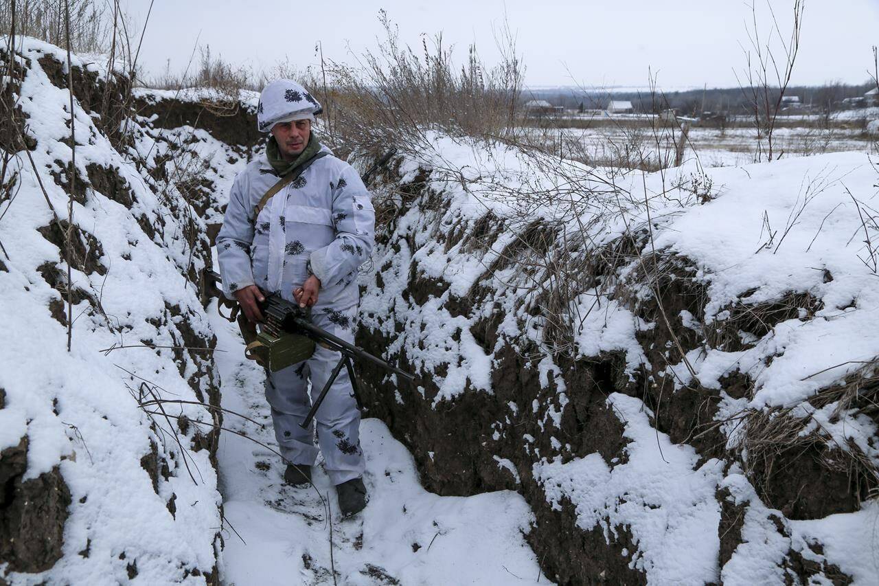 A serviceman stands holding his machine-gun in a trench on the territory controlled by pro-Russian militants at frontline with Ukrainian government forces in Slavyanoserbsk, Luhansk region, eastern Ukraine, Tuesday, Jan. 25, 2022. Ukraine’s leaders sought to reassure the nation that a feared invasion from neighboring Russia was not imminent, even as they acknowledged the threat is real and prepared to accept a shipment of American military equipment Tuesday to shore up their defenses. THE CANADIAN PRESS/AP/Alexei Alexandrov
