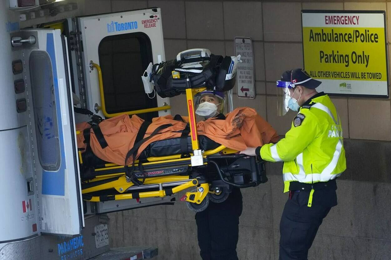 Paramedics transfer a patient out of their ambulance to the emergency department at Michael Garron Hospital during the COVID-19 pandemic in Toronto on Monday, January 10, 2022.THE CANADIAN PRESS/Nathan Denette
