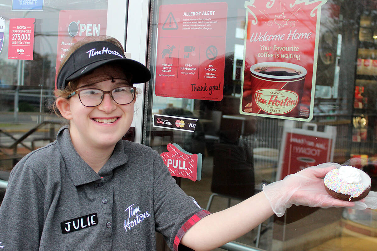 Julie Black, a Special Olympics athlete and Tim Hortons employee, shows off a Choose to Include doughnut, which will be on sale Jan. 28-30 benefiting Special Olympics Canada. (Karl Yu/News Bulletin)