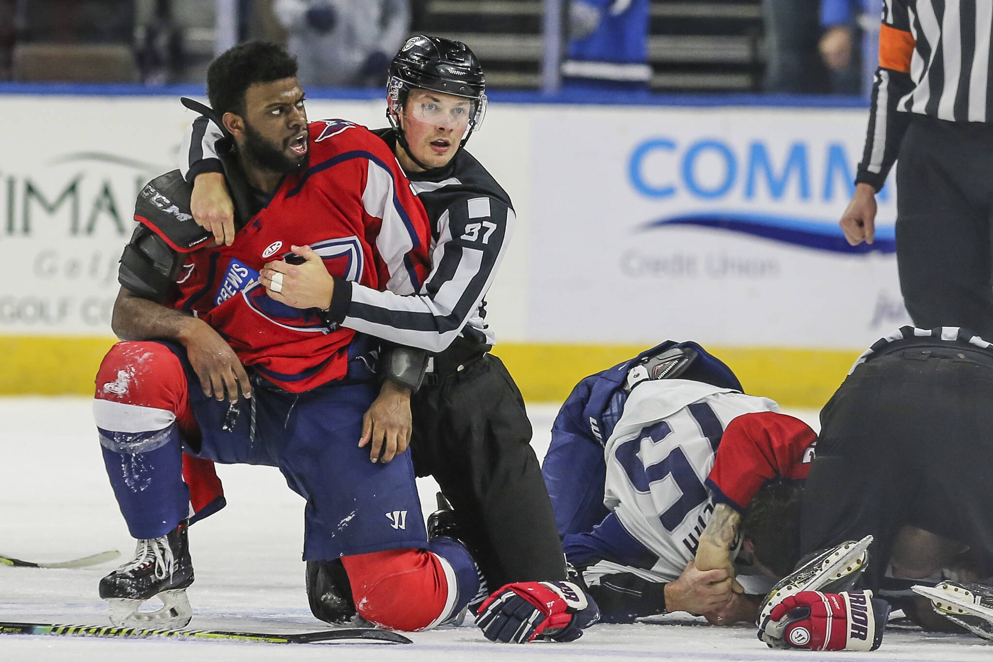 After an on-ice fight, South Carolina Stingrays defenseman Jordan Subban (5), left, is held by linesman Shane Gustafson while Jacksonville Icemen defenseman Jacob Panetta (15) is face-down on the ice engaged with another player during overtime of an ECHL hockey game in Jacksonville, Fla., Saturday, Jan. 22, 2022. The ECHL has suspended Panetta after the brother of longtime NHL defenseman P.K. Subban accused the Jacksonville defenseman of making â€œmonkey gesturesâ€ in his direction. (AP Photo/Gary McCullough)