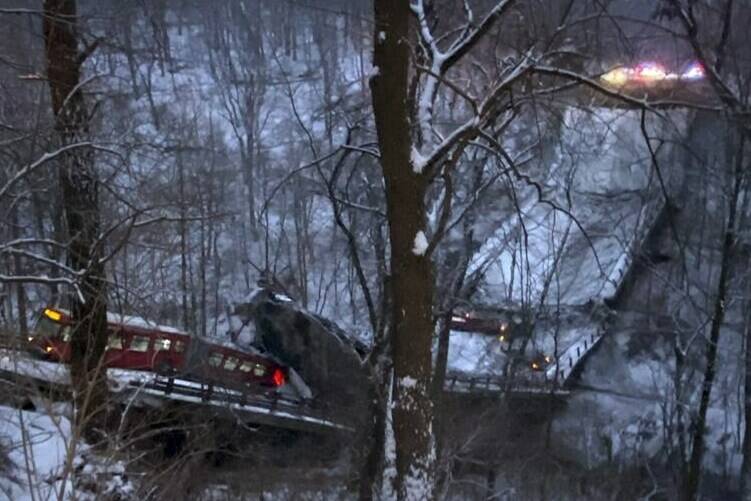 A commuter bus sits upright on a section of a collapsed bridge in Pittsburgh, on Friday, Jan. 28, 2022. Police reported the span, on Forbes Avenue over Fern Hollow Creek in Frick Park, came down around 6 a.m. There were no initial reports of injuries, Pittsburgh Public Safety said on Twitter. (Greg Barnhisel via AP)