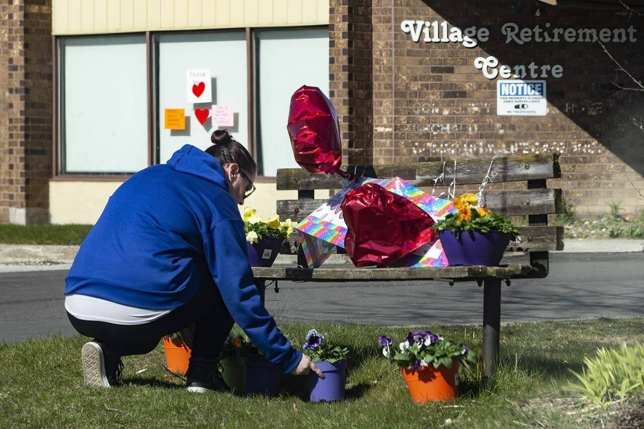 A woman lays flowers outside of Orchard Villa Care home, in Pickering, Ont. on Saturday, April 25, 2020. It’s difficult to forget the tragic scenes that played out in long-term care homes across the country in the early days of the pandemic, as residents died in the thousands, isolated from their loved ones. THE CANADIAN PRESS/Chris Young