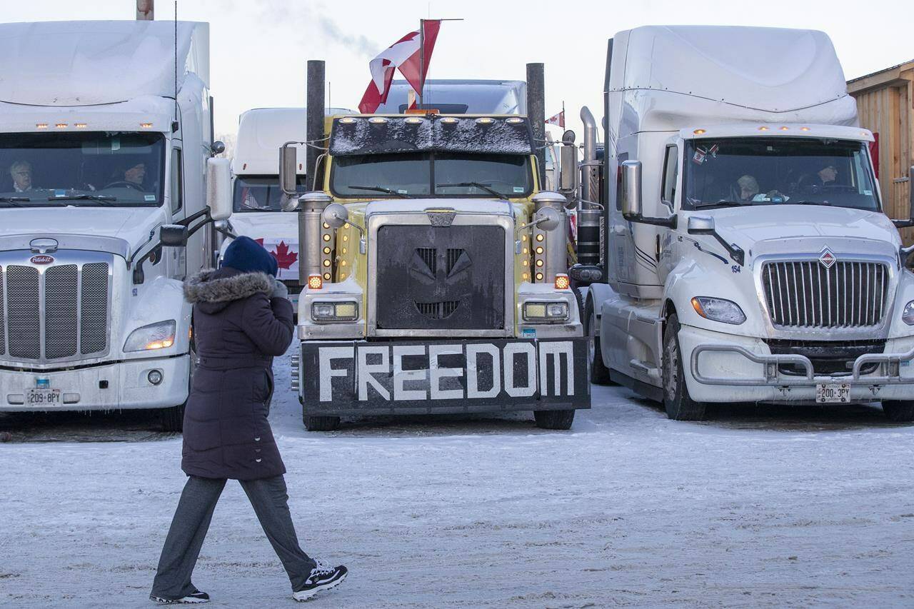 A person walks by a truck with a “Freedom’ on it before the departure of the trucks from Kingston to Ottawa, in Kingston, Ont., on Friday, Jan. 28, 2022. THE CANADIAN PRESS/Lars Hagberg