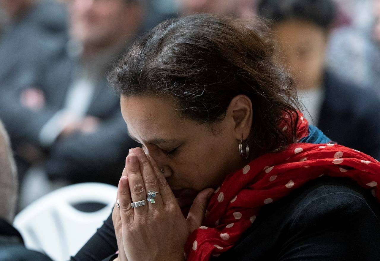 A woman reacts during a speech at a community dinner marking the commemoration of the mosque shooting Wednesday, January 29, 2020 in Quebec City. THE CANADIAN PRESS/Jacques Boissinot