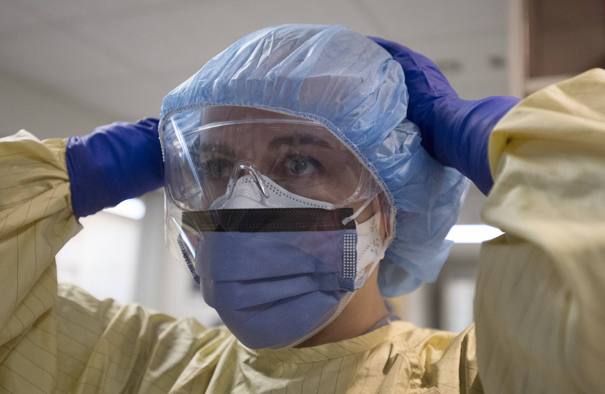 Registered nurse Cayli Hunt puts on her personal protective equipment prior to entering a COVID positive room in the COVID-19 intensive care unit at St. Paul’s hospital in downtown Vancouver, Tuesday, April 21, 2020. THE CANADIAN PRESS/Jonathan Hayward