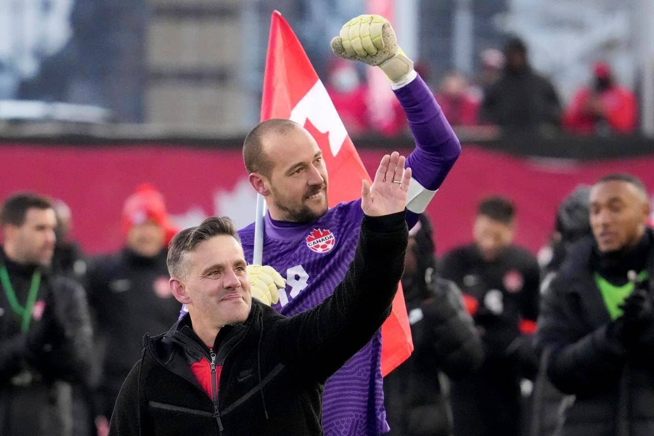 Canada’s Milan Borjan (18) and head coach John Herdman celebrate the team’s 2-0 victory following second half World Cup qualifying soccer action against the United States, in Hamilton, Ont., Sunday, Jan. 30, 2022. THE CANADIAN PRESS/Frank Gunn
