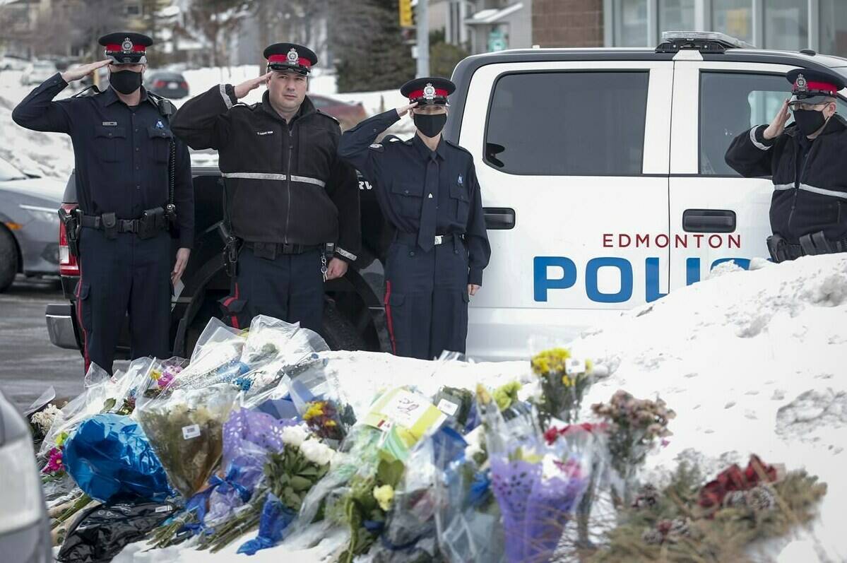 Members of the Edmonton Police Service salute at an impromptu memorial for Calgary Police Service Sgt. Andrew Harnett on Monday, Jan. 4, 2021. A man believed to have been driving the SUV involved in Harnett’s hit-and-run death in December 2020 is on trial charged with first-degree murder. THE CANADIAN PRESS/Jeff McIntosh