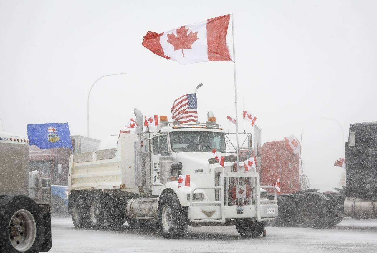 Anti-COVID-19 vaccine mandate demonstrators gather as a truck convoy blocks the highway at the busy U.S. border crossing in Coutts, Alta., Monday, Jan. 31, 2022. THE CANADIAN PRESS/Jeff McIntosh