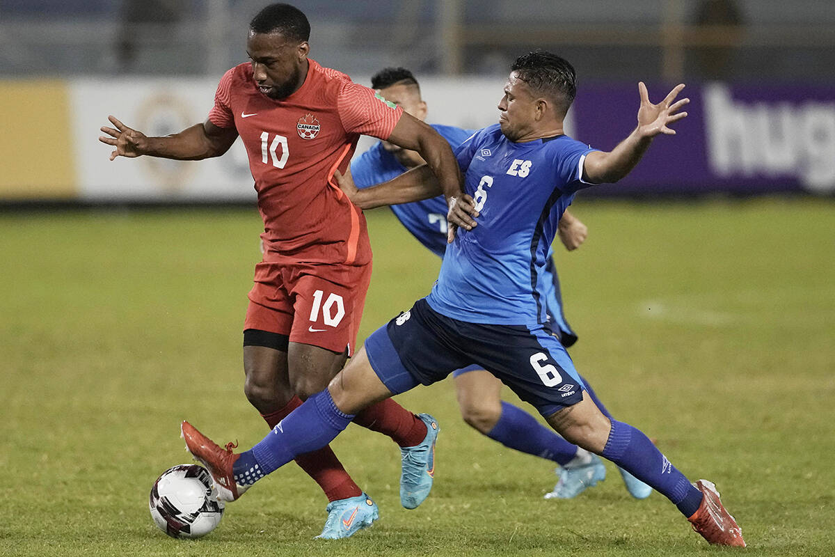 Canada’s David Junior Hoilett, left, fights for the ball with El Salvador’s Narciso Orellana during a qualifying soccer match for the FIFA World Cup Qatar 2022 at Cuscatlan stadium in San Salvador, El Salvador, Wednesday, Feb. 2, 2022. (AP Photo/Moises Castillo)