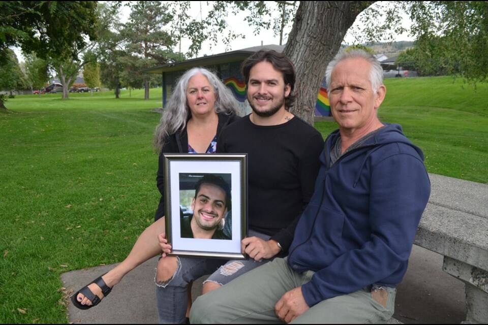 Levi Manson holds a photo of his late brother, Aaron, joined by mom Troylana and dad Bart. This photo was taken in September 2021 at Prince Charles Park in downtown Kamloops. (Michael Potestio/KTW/LJI)