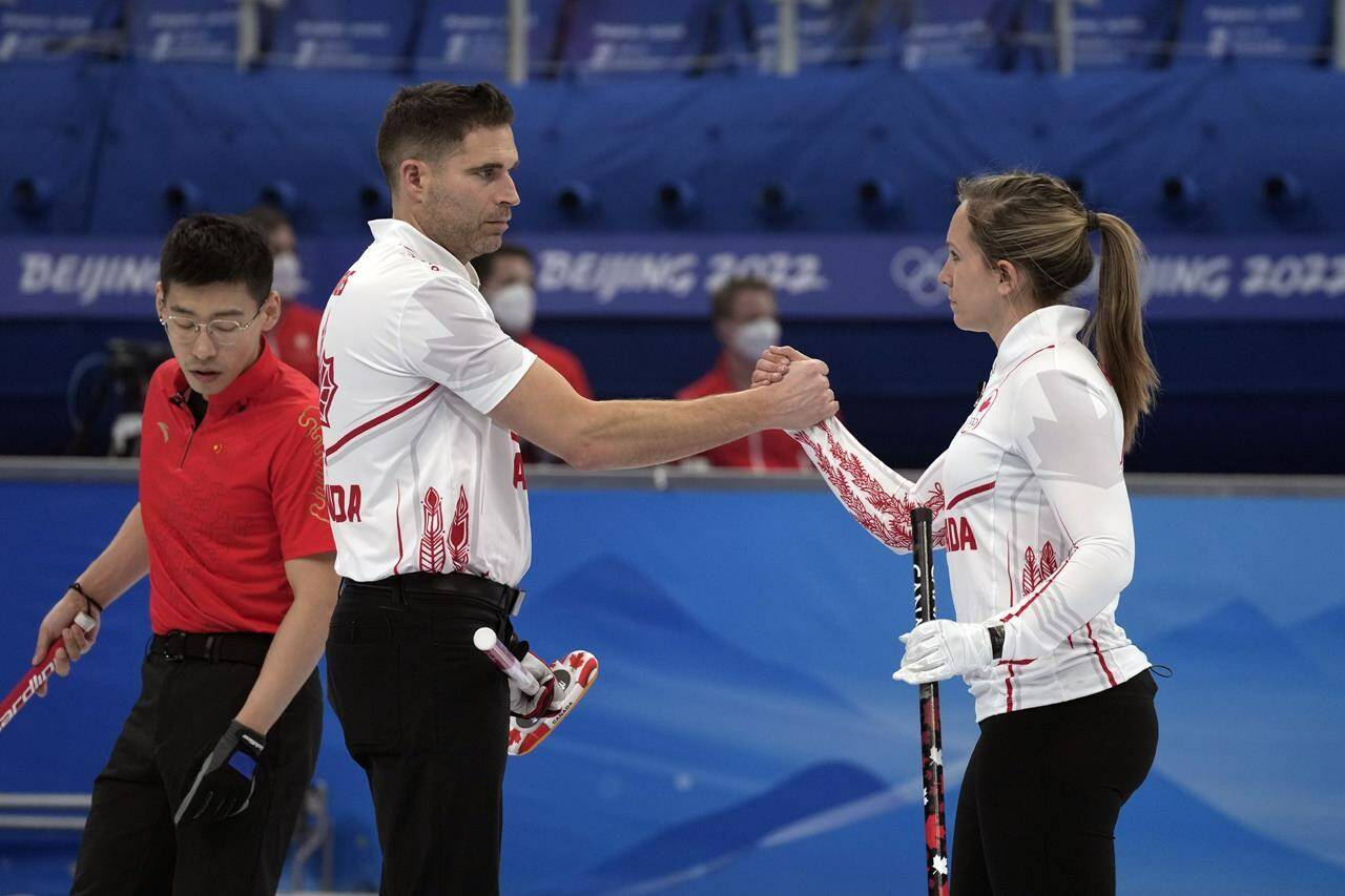 Canada’s John Morris and Rachel Homan, shake hands after winning the mixed doubles curling match against China, at the 2022 Winter Olympics, Friday, Feb. 4, 2022, in Beijing. THE CANADIAN PRESS/AP/Nariman El-Mofty