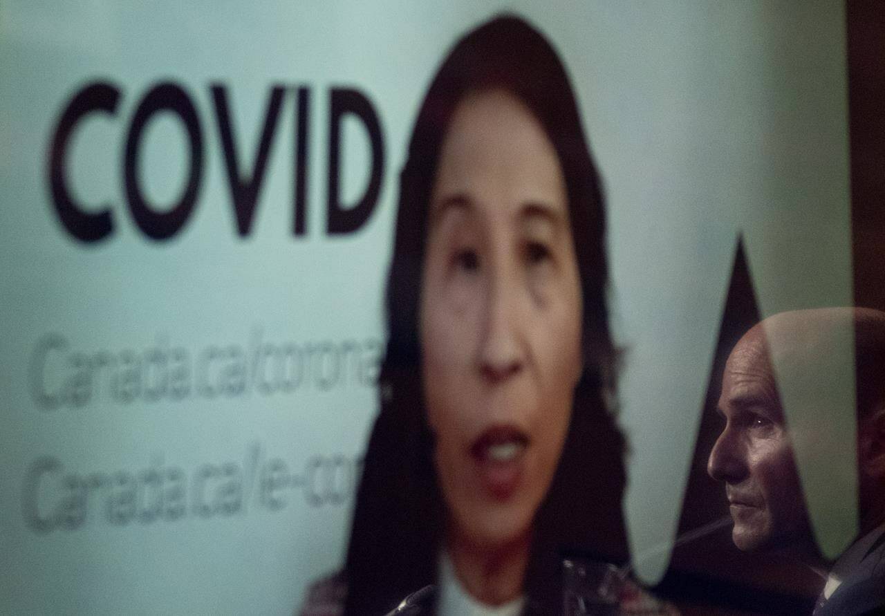 Health Minister Jean-Yves Duclos is reflected on a television screen as Dr. Theresa Tam, Canada’s chief public health officer, appears at a news conference by video conference, Friday, November 26, 2021 in Ottawa. THE CANADIAN PRESS/Adrian Wyld