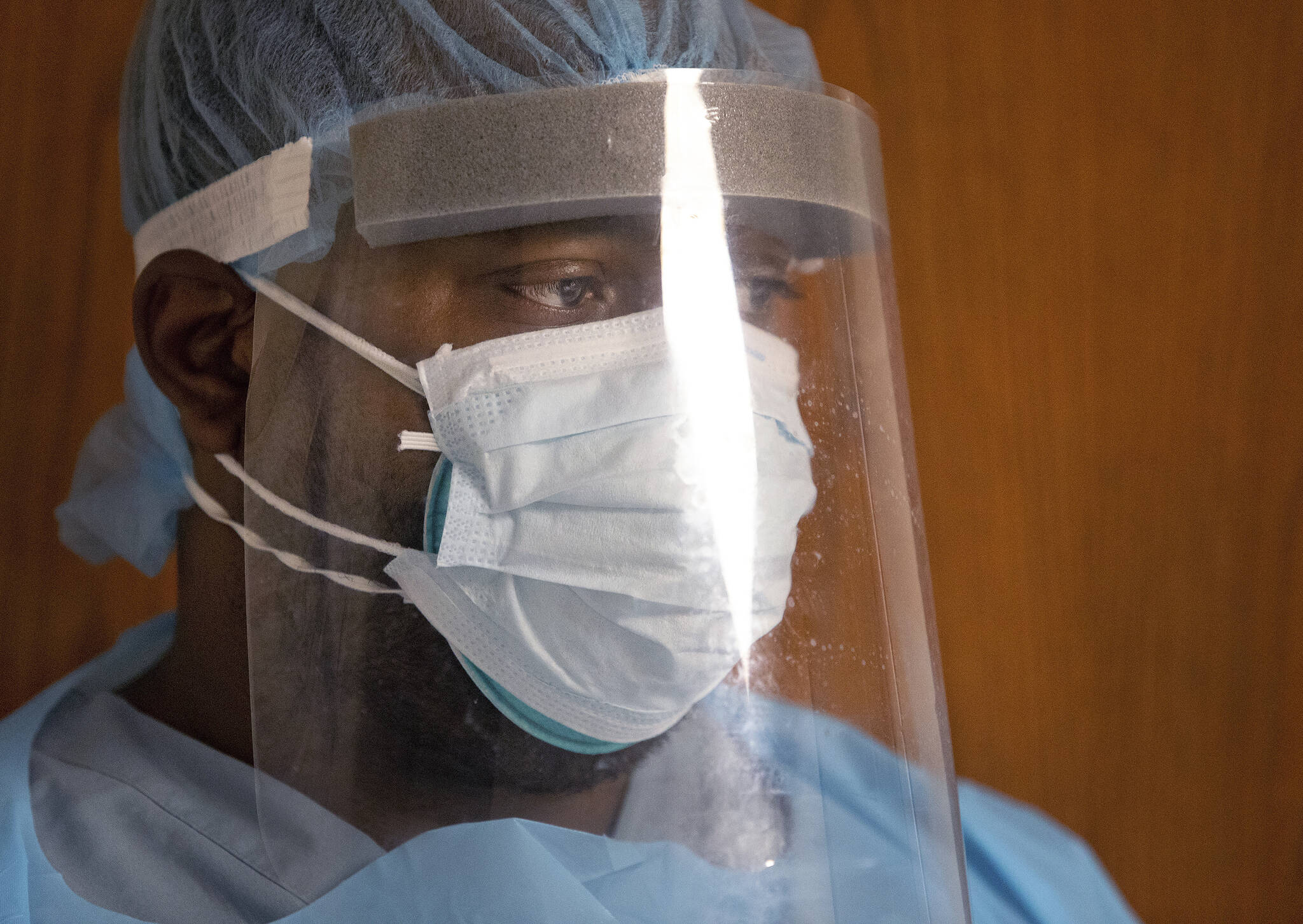 In this Aug. 2, 2021, file photo, COVID ward healthcare worker watches from behind his face shield, double masks and full personal protective equipment as he works with a COVID-19 patient. (AP Photo/Ted Jackson, File)