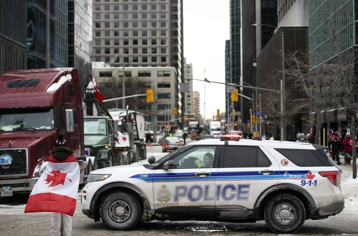 An Ottawa Police vehicle blocks off Kent Street in front of parked trucks as a protest against COVID-19 restrictions that has been marked by gridlock and the sound of truck horns continues into its second week, in Ottawa, on Sunday, Feb. 6, 2022. THE CANADIAN PRESS/Justin Tang