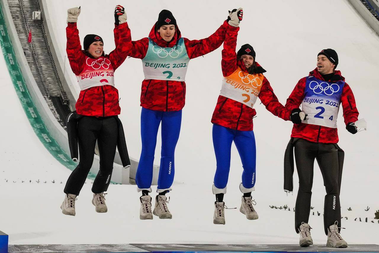 Canada’s Alexandria Loutitt, left, celebrates with teammates Matthew Soukup, Abigail Strate and Mackenzie Boyd-Clowes during the the venue ceremony after winning a bronze in the ski jumping mixed team event at the 2022 Winter Olympics, Monday, Feb. 7, 2022, in Zhangjiakou, China. THE CANADIAN PRESS/AP/Matthias Schrader