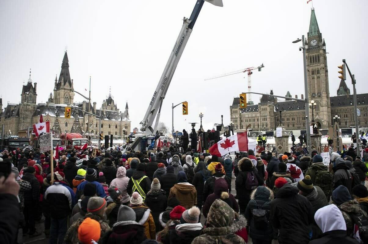 People listen to a sermon delivered by a pastor from the back of a flatbed truck parked on Wellington Street in front of Parliament Hill as a protest against COVID-19 restrictions that has been marked by gridlock and the sound of truck horns continues into its second week, in Ottawa, on Sunday, Feb. 6, 2022. Sixty two per cent of Canadians oppose the Freedom Convoy protests, with 44 per cent saying they strongly object to them, according to a Leger poll. THE CANADIAN PRESS/Justin Tang