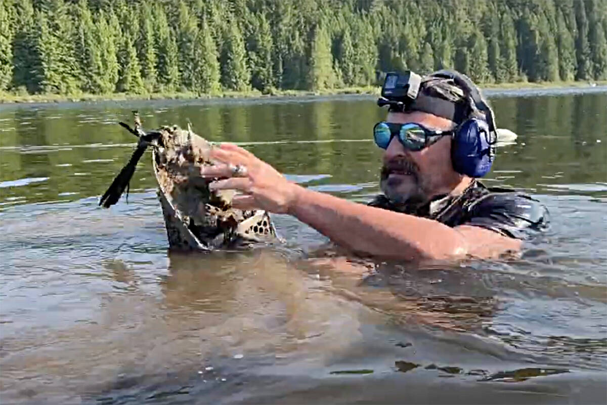 Ring Finder’s Chris Turner, neck deep in Rolley Lake with his underwater metal detector, searching for a lost gold during one of his recoveries. (Screenshot from Ring Finders YouTube video.)