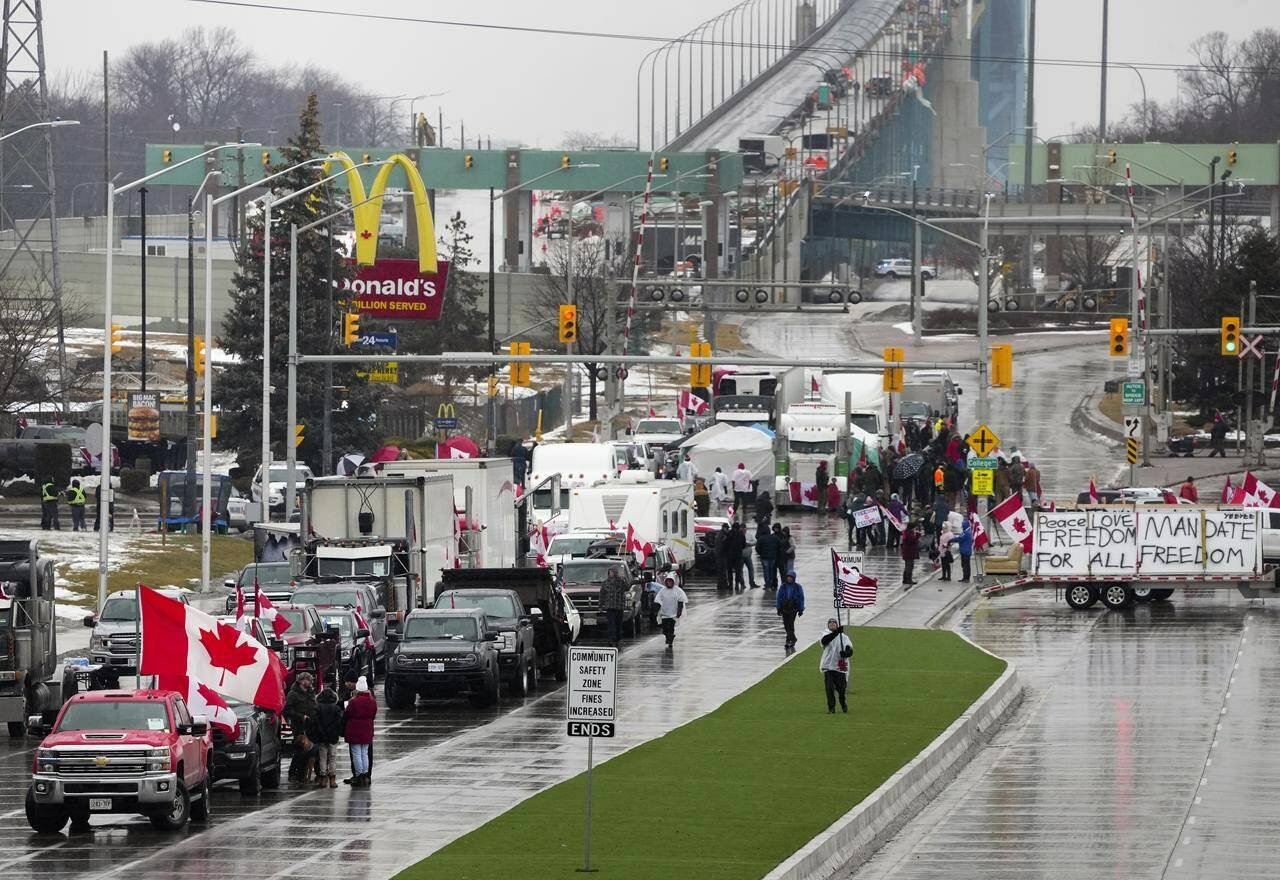 Truckers and supporters block the access leading from the Ambassador Bridge, linking Detroit and Windsor, as truckers and their supporters continue to protest against COVID-19 vaccine mandates and restrictions, in Windsor, Ont., Friday, Feb. 11, 2022. THE CANADIAN PRESS/Nathan Denette