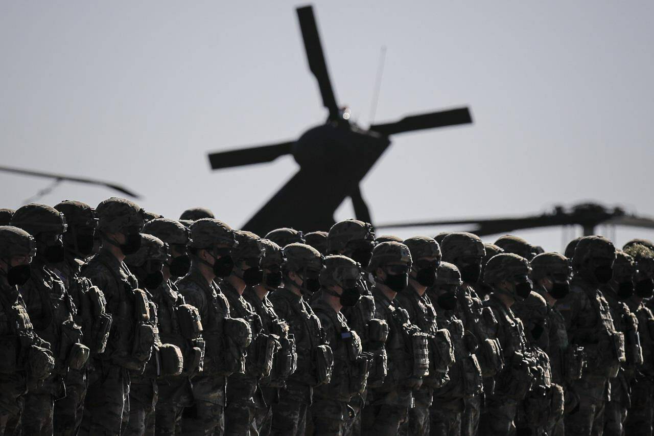 US soldiers line up during the visit of NATO Secretary General Jens Stoltenberg at the Mihail Kogalniceanu airbase, near the Black Sea port city of Constanta, eastern Romania, Friday, Feb. 11, 2022. Stoltenberg paid an official visit to Romania on Friday, where he joined the country’s president Klaus Iohannis at a military airbase that will host some of the 1,000 U.S. troops deployed to the country as the alliance bolsters its forces on the eastern flank as tensions soar between Russia and Ukraine. (AP Photo/Andreea Alexandru)