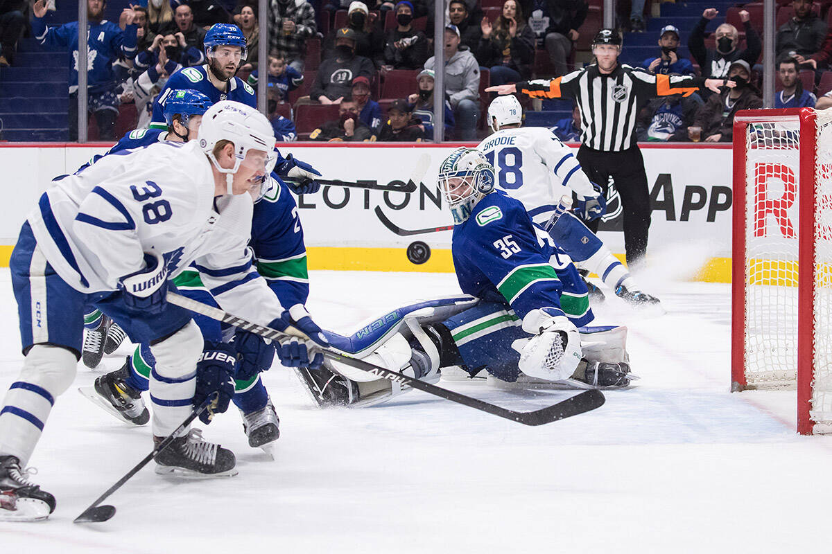 Vancouver Canucks goalie Thatcher Demko (35) and Toronto Maple Leafs’ Rasmus Sandin (38), of Sweden, watch the puck after Demko made the save during the first period of an NHL hockey game in Vancouver, on Saturday, February 12, 2022. THE CANADIAN PRESS/Darryl Dyck