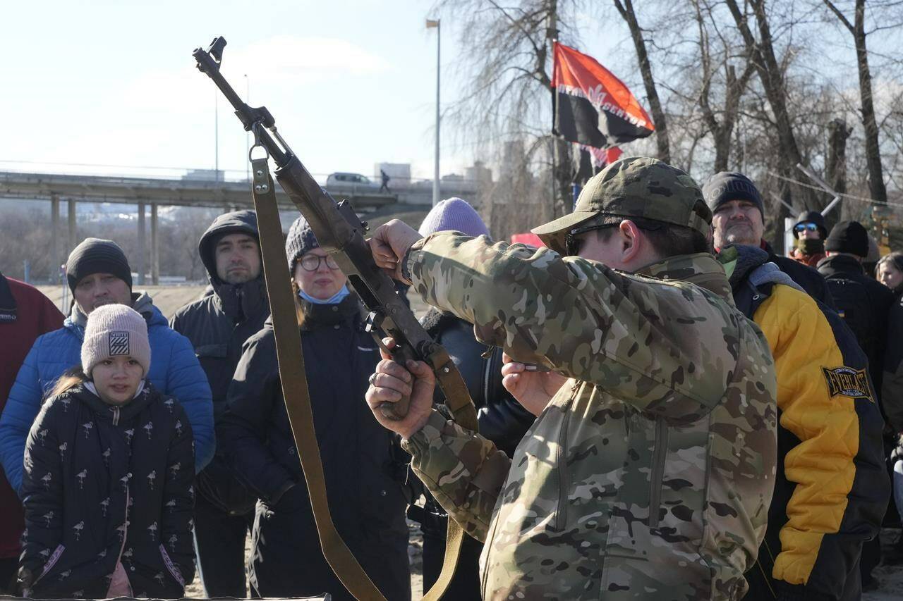 An instructor shows a Kalashnikov assault rifle as members of a Ukrainian far-right group train, in Kyiv, Ukraine, Sunday, Feb. 13, 2022. Russia denies it intends to invade but has massed well over 100,000 troops near the Ukrainian border and has sent troops to exercises in neighboring Belarus, encircling Ukraine on three sides. U.S. officials say Russia’s buildup of firepower has reached the point where it could invade on short notice. (AP Photo/Efrem Lukatsky)