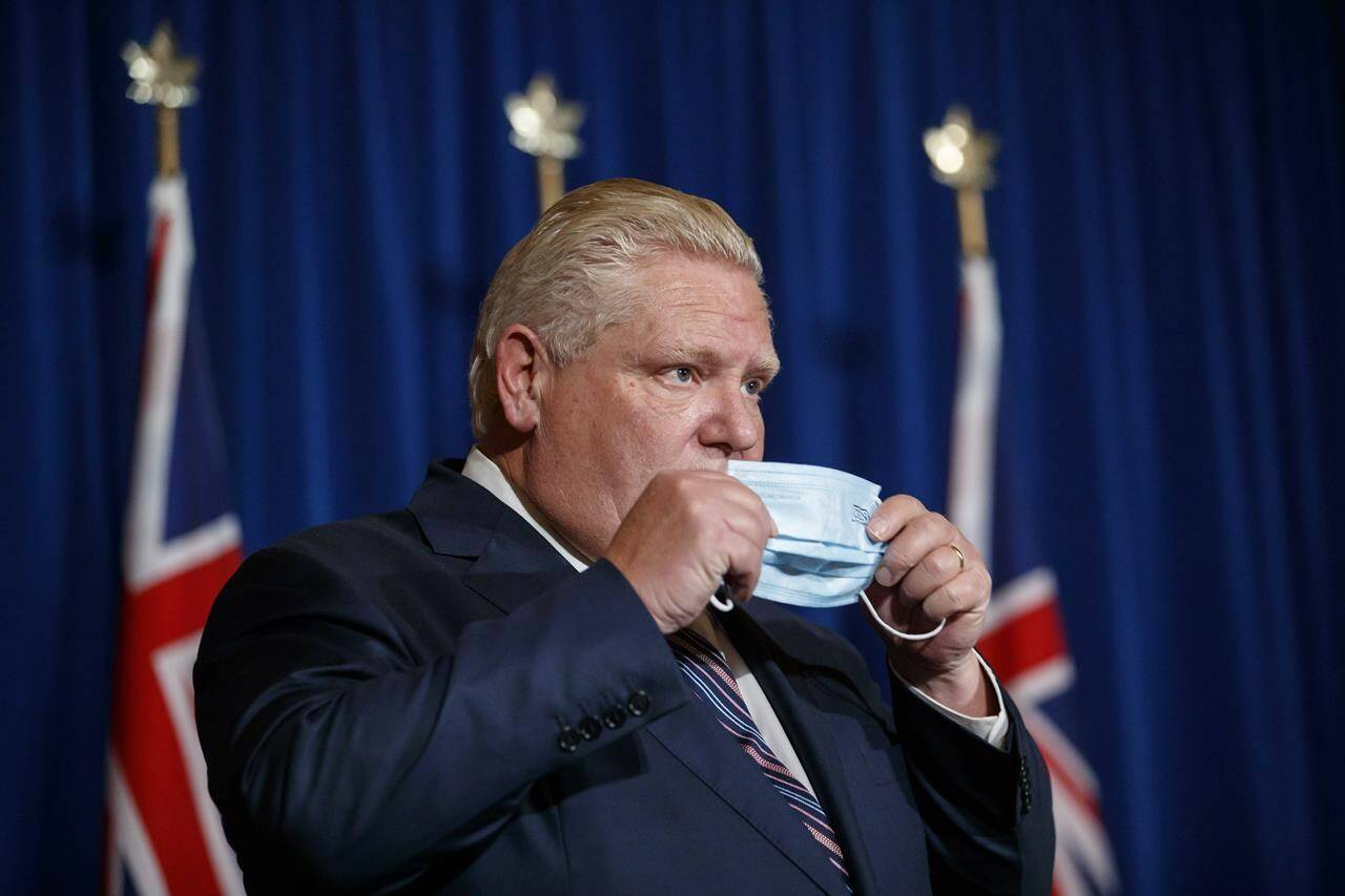 Ontario Premier Doug Ford puts his mask back on after speaking during a news conference at Queen’s Park in Toronto, Wednesday, Dec. 15, 2021. Public health responses to protect against the Omicron variant vary across Canada, even as COVID-19 cases continue to rise in the country’s two most populous provinces. THE CANADIAN PRESS/Cole Burston