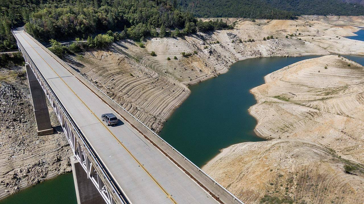 FILE - A car crosses Enterprise Bridge over Lake Oroville’s dry banks on May 23, 2021, in Oroville, Calif. The American West’s megadrought deepened so much last year that it is now the driest it has been in at least 1200 years and a worst-case scenario playing out live, a new study finds. (AP Photo/Noah Berger, File)