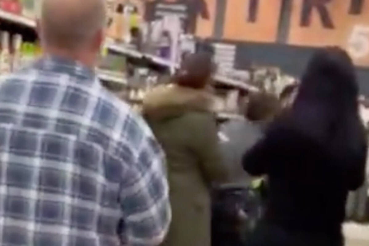 A still from a video posted on Twitter in which a man is seen punching an employee in the head in an aisle of the Garrison Crossing Save-On-Foods in Chilliwack on Jan. 26, 2022. (Twitter)