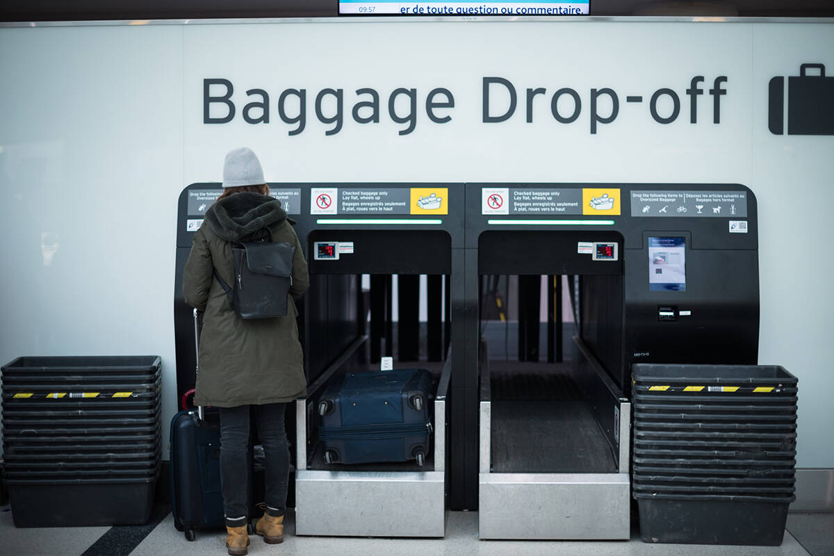 A traveler drops off their baggage at Toronto Pearson International Airport, on Thursday, December 16, 2021. The federal government is warning Canadians against non-essential travel internationally due to the risk of the Omicron variant that causes COVID-19. THE CANADIAN PRESS/Tijana Martin