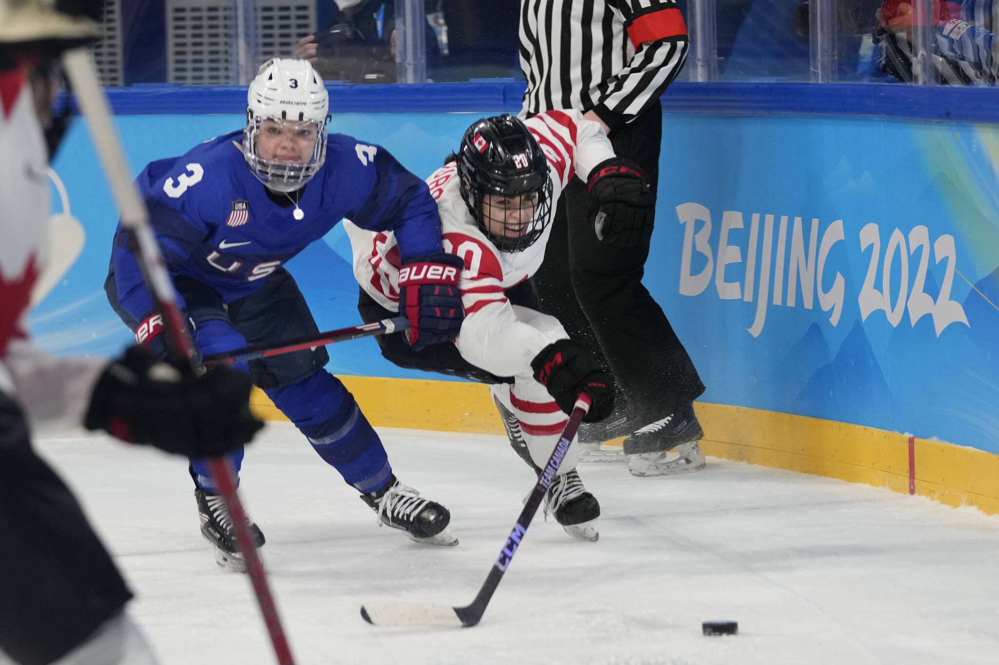 United States’ Cayla Barnes (3) and Canada’s Sarah Nurse (20) chase the puck during a preliminary round women’s hockey game at the 2022 Winter Olympics, Tuesday, Feb. 8, 2022, in Beijing. (AP Photo/Petr David Josek)