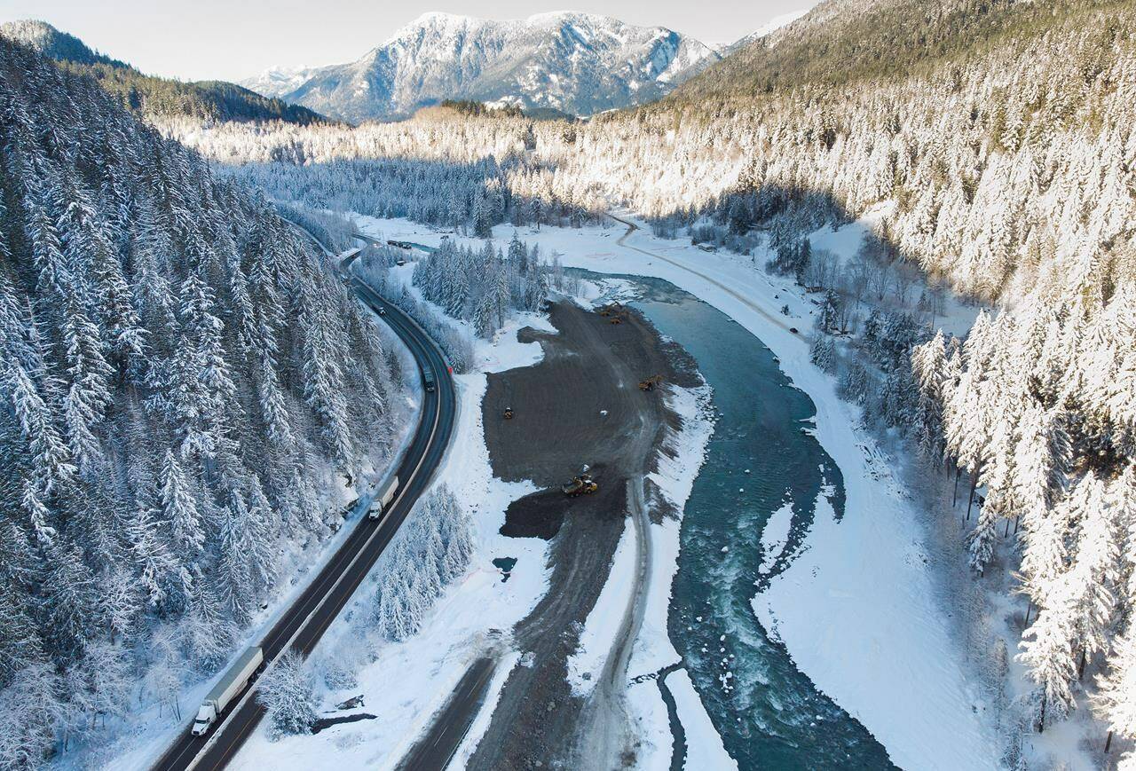 Transport trucks hauling trailers travel on the Coquihalla Highway after it was reopened to commercial traffic as heavy equipment is used to rebuild the southbound lanes that were washed away by flooding last month at Othello, northeast of Hope, B.C., on Monday, December 20, 2021. THE CANADIAN PRESS/Darryl Dyck