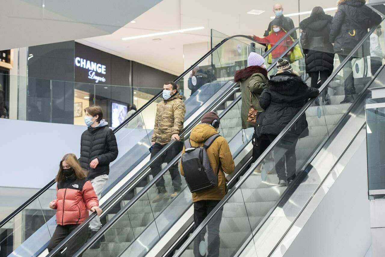 People ride an escalator at a shopping mall in Montreal, Saturday, January 15, 2022, as the COVID-19 pandemic continues in Canada. THE CANADIAN PRESS/Graham Hughes