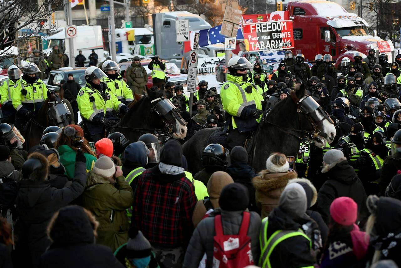 Toronto Police mounted unit charges the crowd in a dispersion tactic as police take action to put an end to a protest, which started in opposition to mandatory COVID-19 vaccine mandates and grew into a broader anti-government demonstration and occupation, in Ottawa, Friday, Feb. 18, 2022. THE CANADIAN PRESS/Justin Tang