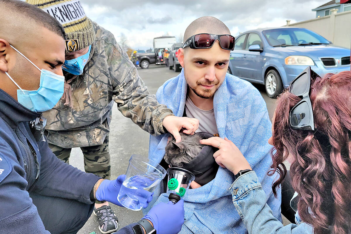 Passerby Lucas Wilde cradled a cat that was administered oxygen after it escaped a multi-unit residential fire in Langley near 216th St. and 56th Avenue on Sunday, Feb. 20. No serious injuries were reported. (Dan Ferguson/Langley Advance Times)