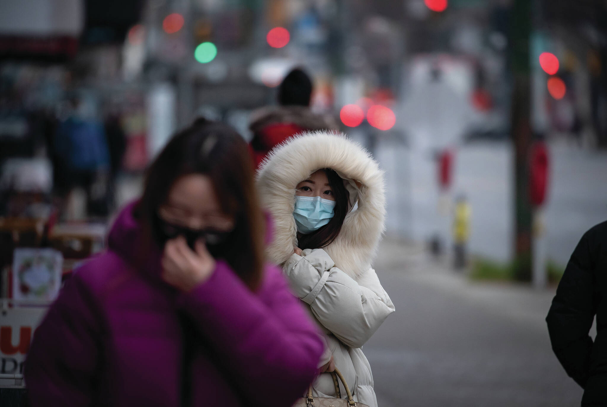 A person bundled up in a heavy jacket for the cold weather wears a face mask to curb the spread of COVID-19 in Vancouver, on Tuesday, December 21, 2021. THE CANADIAN PRESS/Darryl Dyck
