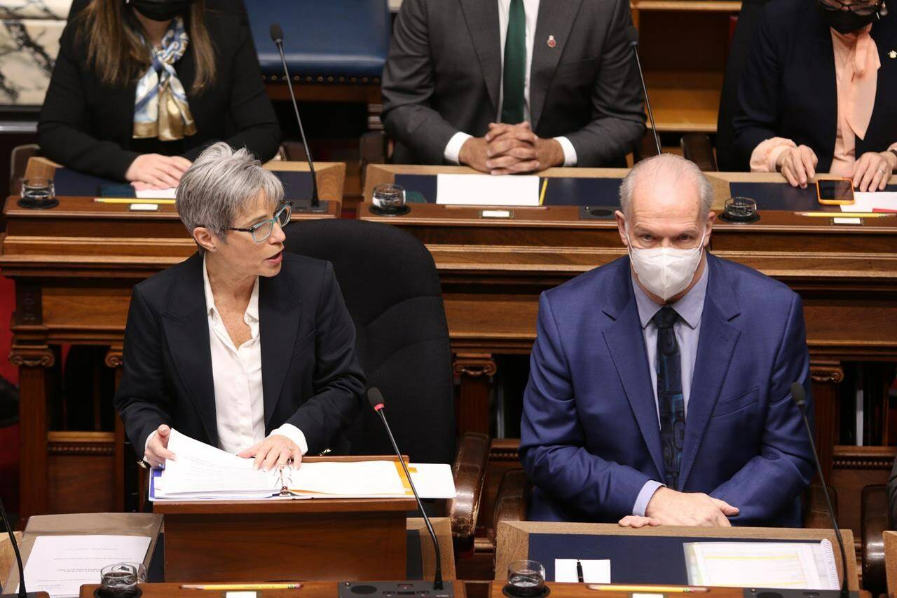 B.C. Premier John Horgan looks on as Finance Minister Selina Robinson delivers the budget speech in the legislature in Victoria on Tuesday, February 22, 2022. THE CANADIAN PRESS/Chad Hipolito