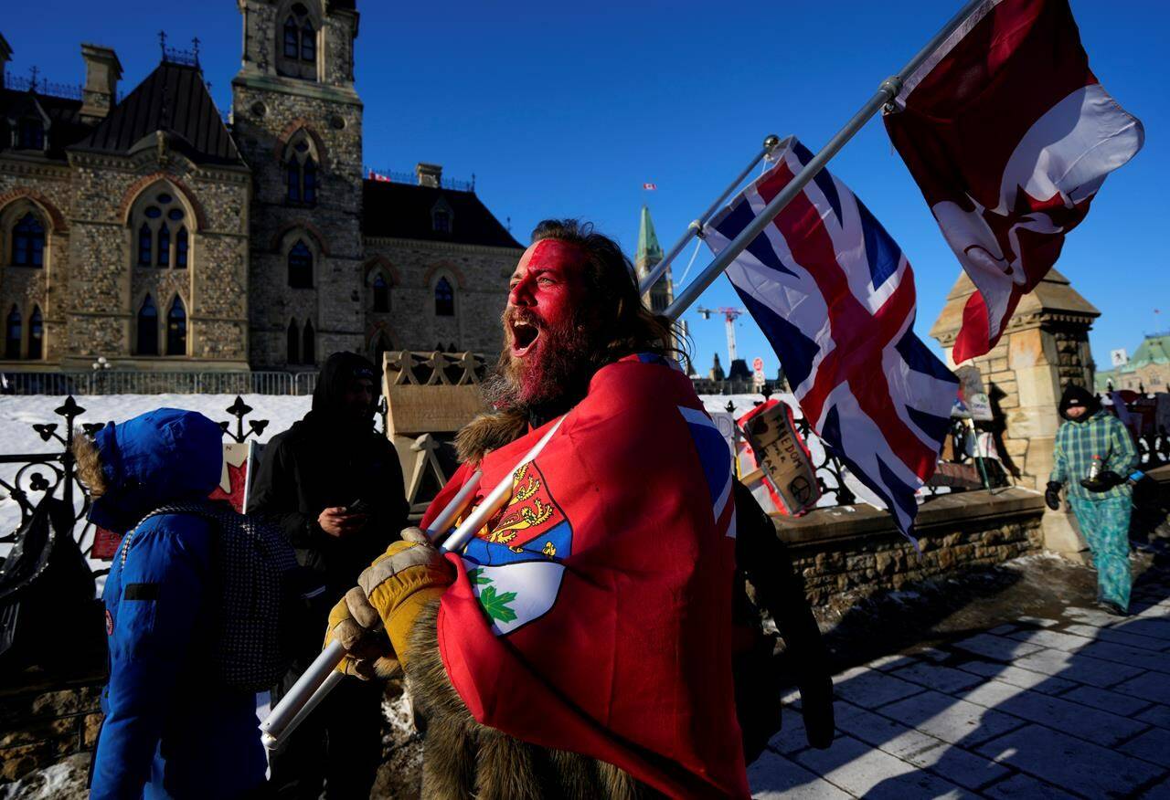 A protester yells “freedom” towards a person who attempted to stick a paper sign on a truck criticizing the so-called “Freedom Convoy,” a protest against COVID-19 measures that has grown into a broader anti-government protest, on its 18th day, in Ottawa, on Monday, Feb. 14, 2022. THE CANADIAN PRESS/Justin Tang