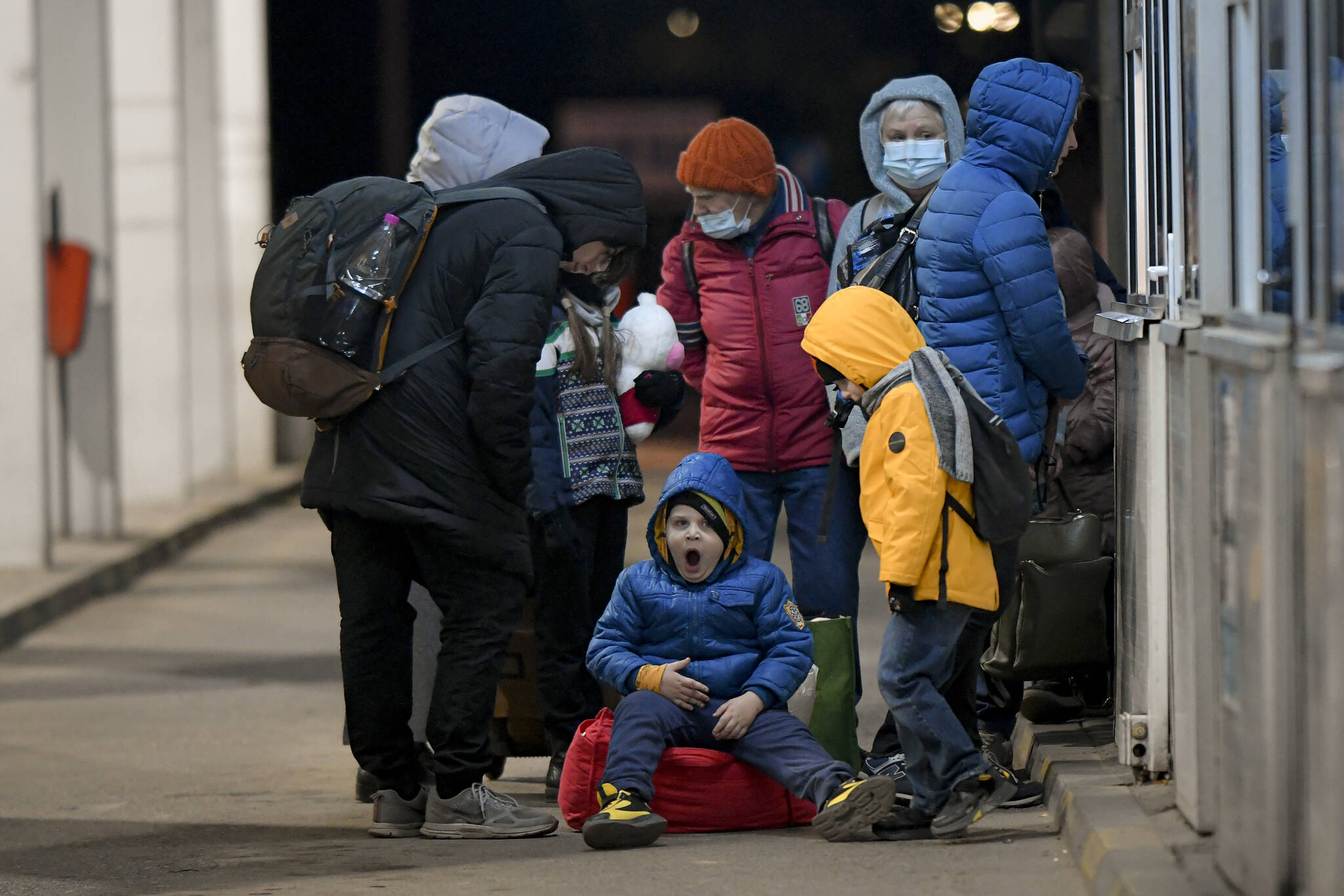 A child from Ukraine yawns as he waits to gain entry into Romania at the Romanian-Ukrainian border, in Siret, Romania, Friday, Feb. 25, 2022. Romania, which shares around 600 kilometres (372 miles) of borders with Ukraine to the north, is seeing an influx of refugees from the country as many flee Russia’s attacks. (AP Photo/Andreea Alexandru)