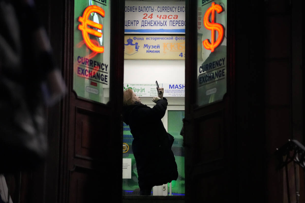 A woman stands in a currency exchange office in St. Petersburg, Russia, Friday, Feb. 25, 2022. Russians flocked to banks and ATMs on Thursday and Friday shortly after Russia launched an attack on Ukraine and the West announced crippling sanctions. According to Russia’s Central Bank, on Thursday alone Russians have withdrawn 111 billion rubles (about $1.3 billion) in cash. (AP Photo/Dmitri Lovetsky)