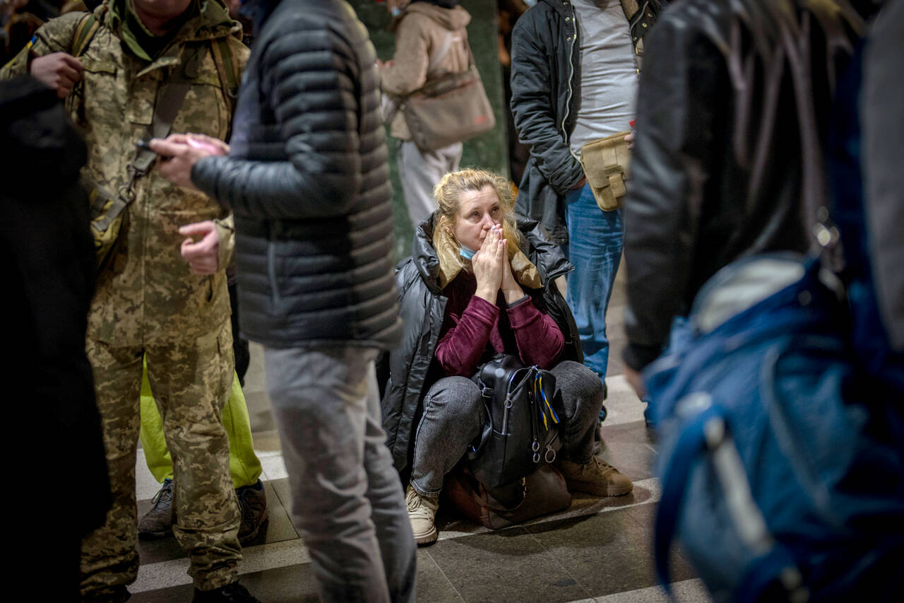 A woman reacts as she waits for a train trying to leave Kyiv, Ukraine, Thursday, Feb. 24, 2022. Russian troops have launched their anticipated attack on Ukraine. Big explosions were heard before dawn in Kyiv, Kharkiv and Odesa as world leaders decried the start of an Russian invasion that could cause massive casualties and topple Ukraine’s democratically elected government. (AP Photo/Emilio Morenatti)
