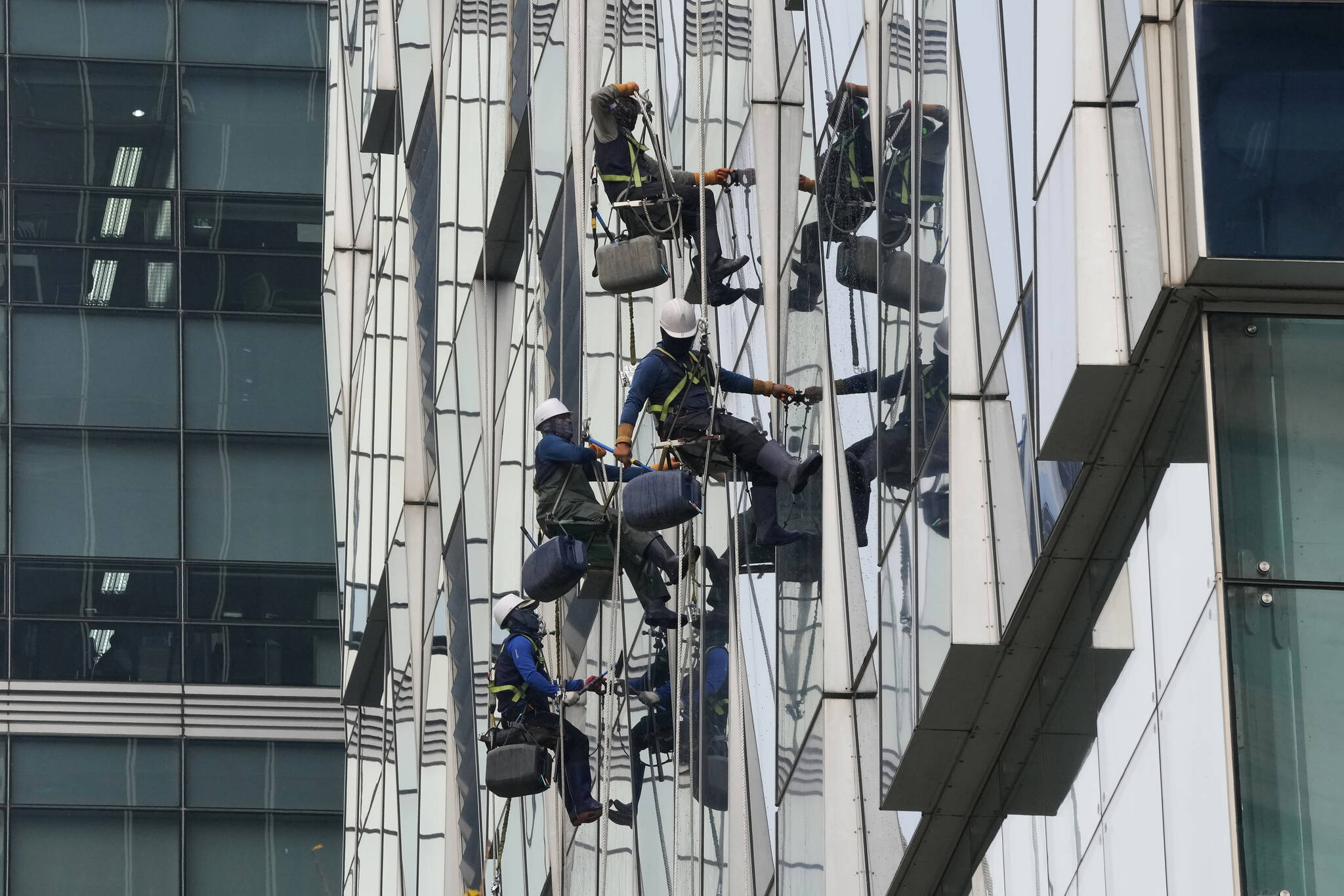 Window cleaners hang from ropes to clean the an office building’s windows in Seoul, South Korea, Friday, Nov. 19, 2021. (AP Photo/Ahn Young-joon).