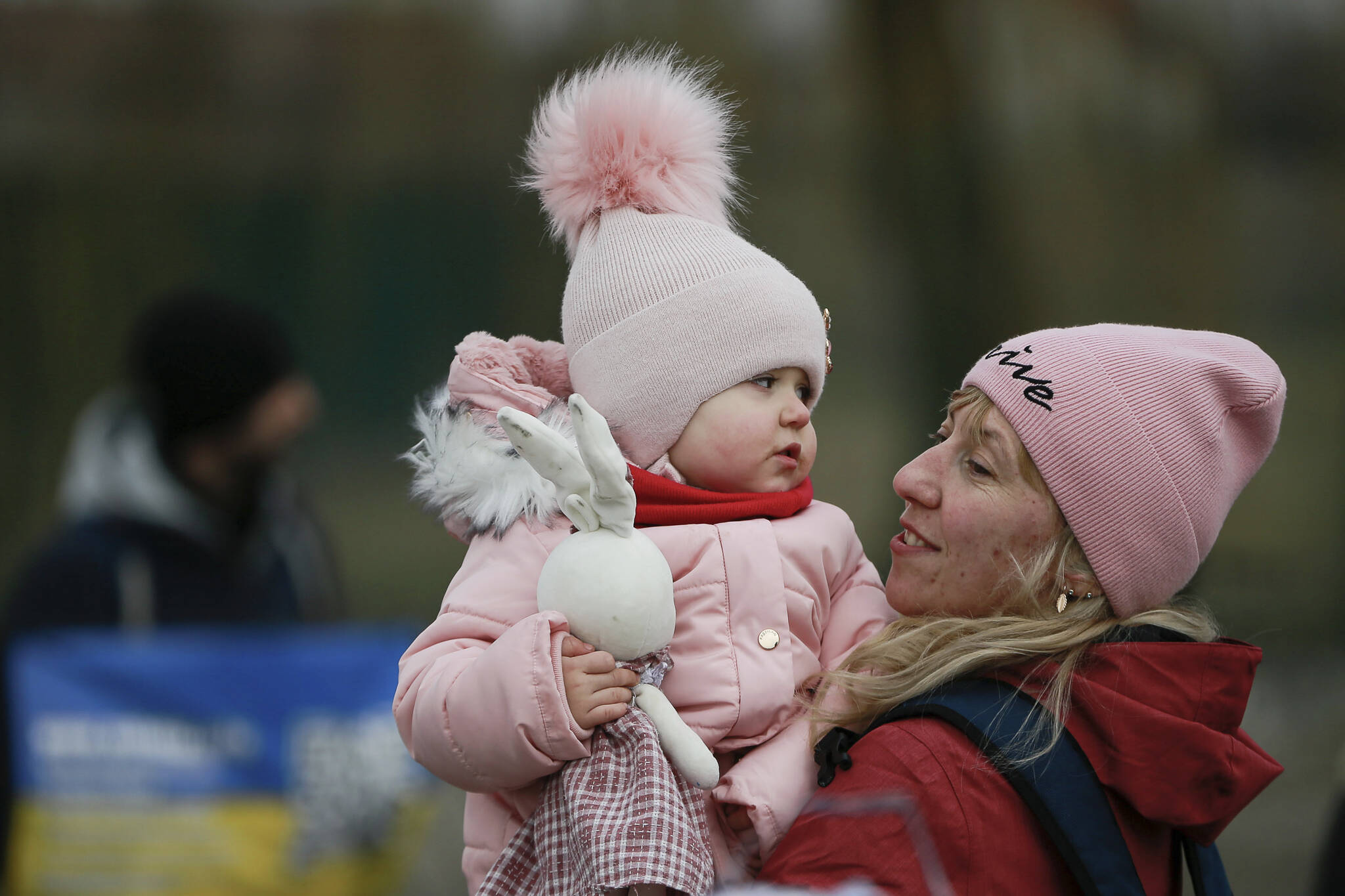 A woman holds a girl at a border crossing in Medyka, Poland, Thursday, March 3, 2022, as they flee the Russian invasion. The U.N. refugee agency said Thursday at least 1 million people have fled Ukraine since Russia’s invasion a week ago, an exodus without precedent in this century for its speed. (AP Photo/Visar Kryeziu)