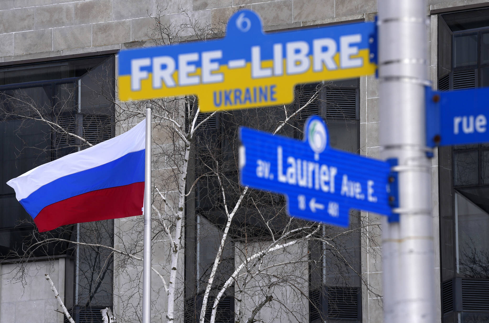 The flag of Russia flies at the Embassy of Russia in Ottawa behind a street sign calling for a free Ukraine, installed on posts adjacent to the road as a gesture of solidarity by the City of Ottawa, as Russia continues its invasion of Ukraine, on Wednesday, March 2, 2022. THE CANADIAN PRESS/Justin Tang