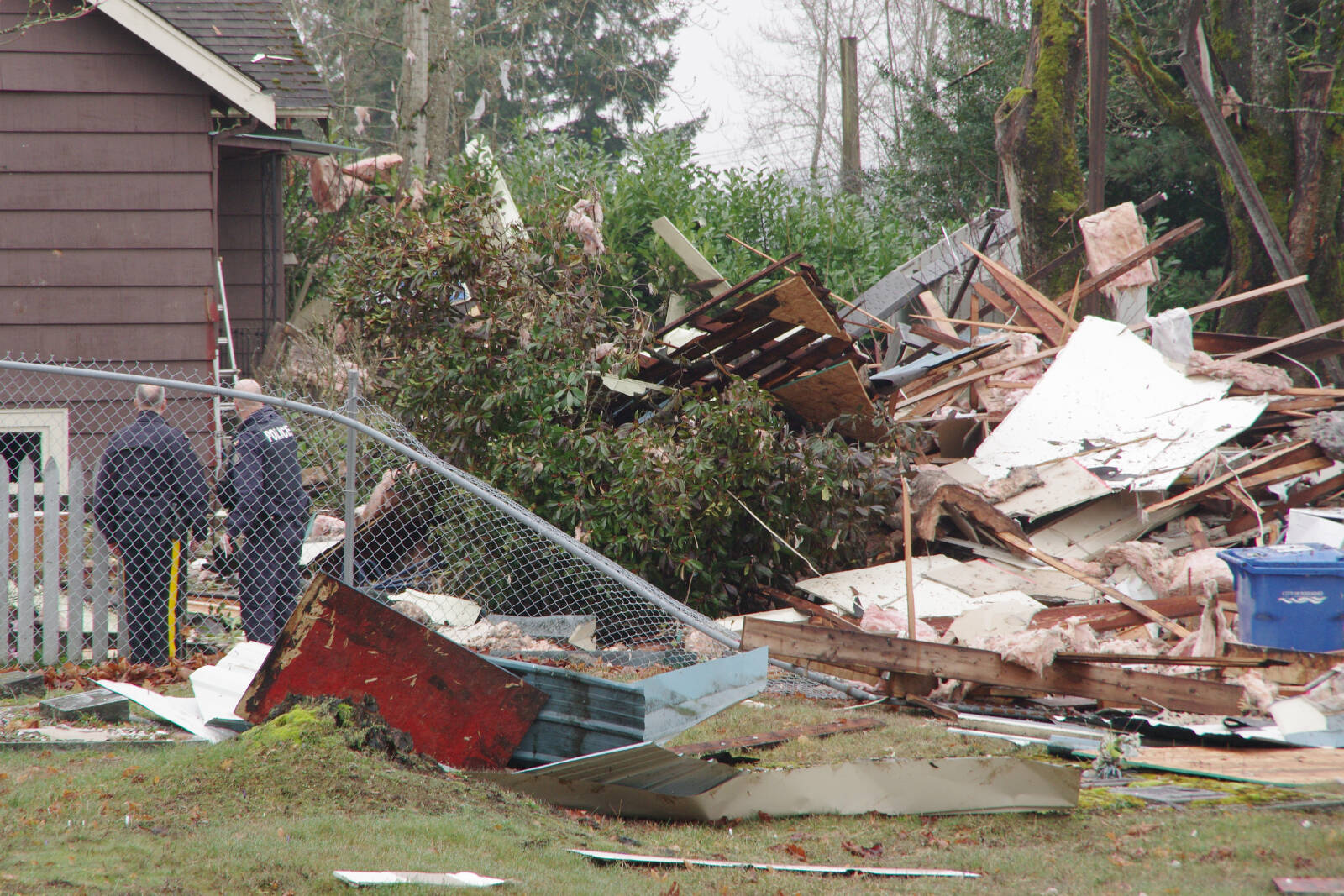 Nanaimo RCMP officers investigate a property on Pine Street the morning after a house exploded on Sunday, Feb. 27. (Chris Bush/News Bulletin)